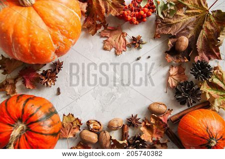 Three Pumpkins, Maple Leaves, Pecans And Spices Over White Stone Baclground. Autumn Season, Thanksgi