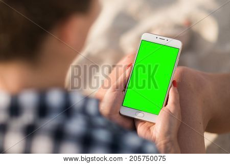 Beautiful girl holding a smartphone in the hands of a green screen green screen, hand of man holding mobile smart phone with chroma key green screen on white background, new technology concept