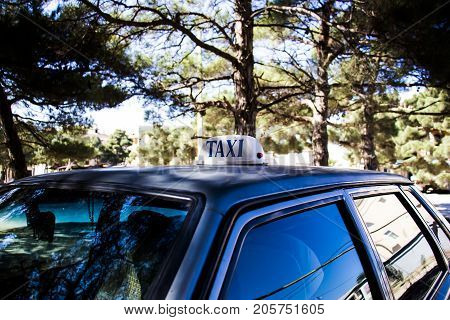 Taxi inscription on the roof of the car standing on the street