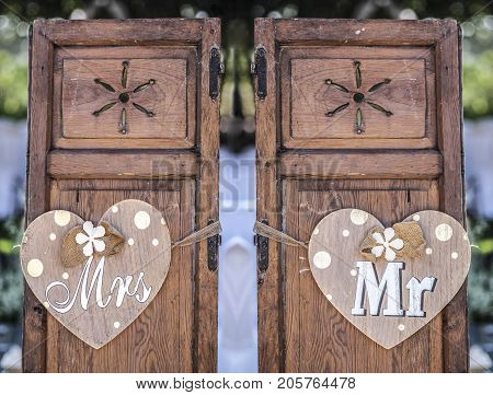 Old wooden shutter windows with hanging hearts for Mrs and Mr. Vintage decoration for weddings