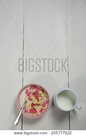 Overhead of honeycomb cereal and milk on wooden table