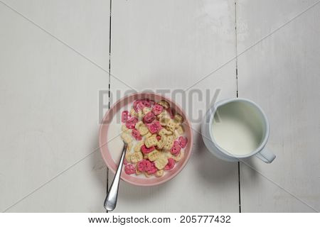 Overhead of honeycomb cereal and milk on wooden table