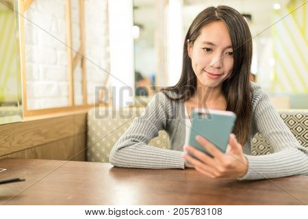 Woman using mobile phone in restauarnt 