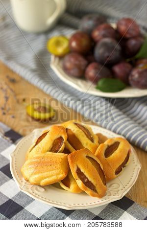 Madeleine With Plums And Plums. French Cookies. Rustic Style, Selective Focus.