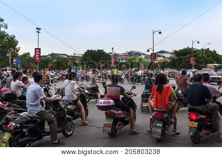 Guilin China - July 31 2012: Large group of motorcycles in a traffic jam in a cross road in the city of Guilin in China