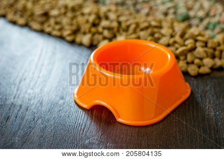 Small orange bowl for pet food and dry food as background