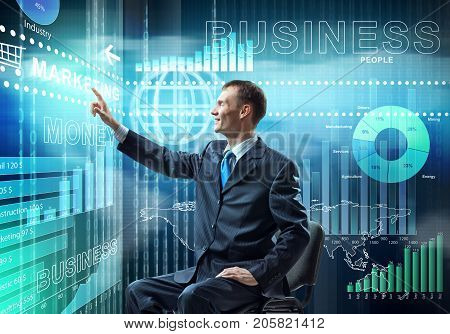 Young businessman sitting on chair and working with virtual panel