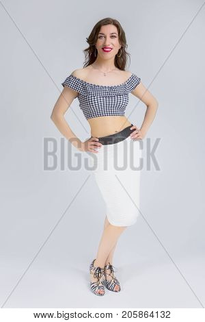 Natural Portrait of Sexy and Sensual Attractive Caucasian Brunette Model Posing in White Pleated Skirt and Tartar Bra.Vertical Image