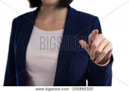 Mid section of businesswoman touching invisible screen against white background