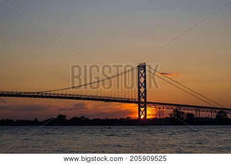 View of Ambassador Bridge connecting Windsor, Ontario to Detroit Michigan at sunset time