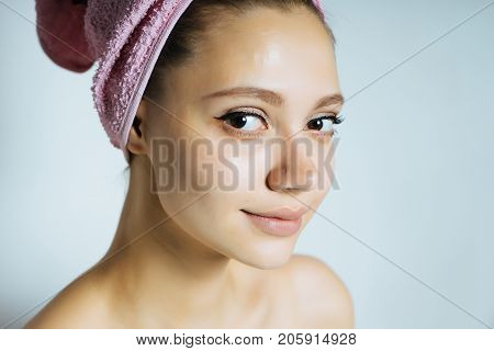 Beautiful young girl in towel on head with clean skin