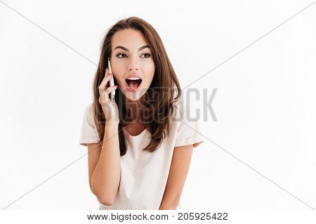 Surprised happy talking on smartphone and looking away over white background