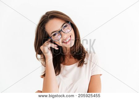 Pretty smiling woman in eyeglasses looking at the camera over white background