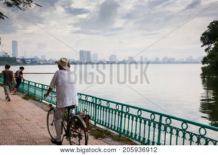 HANOI, VIETNAM - AUGST 2017:  People doing workout in the early morning near Truc Bach lake in Hanoi, Vietnam