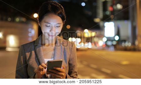 Business woman use of cellphone and waiting for taxi