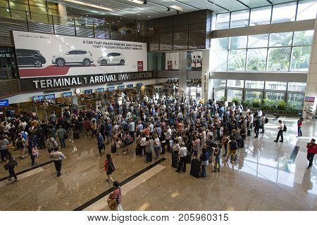Changi Airport, Singapore: March 05, 2017: People wait to pass through immigration at Changi Airport. Changi Airport is one of the largest transportation hubs in Southeast Asia.
