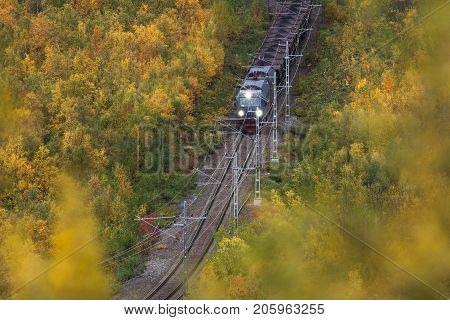IRON ORE LINE, SWEDEN ON SEPTEMBER 13. View of a train pass through the colorful landscape on September 13, 2017 along the Iron Ore Line, Sweden. Train, railroad and forest. Editorial use.