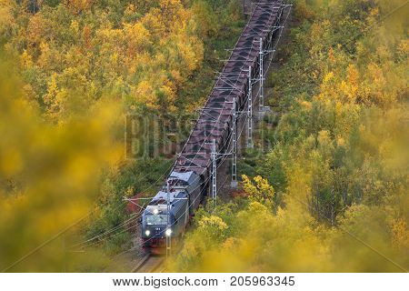 IRON ORE LINE, SWEDEN ON SEPTEMBER 13. View of a train pass through the colorful landscape on September 13, 2017 along the Iron Ore Line, Sweden. Train, railroad and forest. Editorial use.