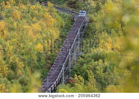 IRON ORE LINE, SWEDEN ON SEPTEMBER 11. View of a train pass through the colorful landscape on September 11, 2017 along the Iron Ore Line, Sweden. Train, railroad and forest. Editorial use.