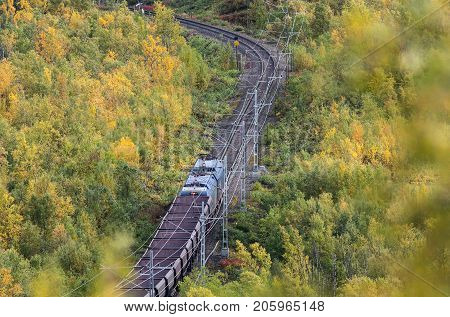 IRON ORE LINE, SWEDEN ON SEPTEMBER 11. View of a train pass through the colorful landscape on September 11, 2017 along the Iron Ore Line, Sweden. Train, railroad and forest. Editorial use.