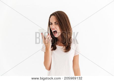 Brunette woman screaming on her smartphone over white background