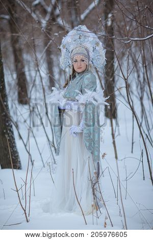 woman in a Snow Maiden costume in a winter forest