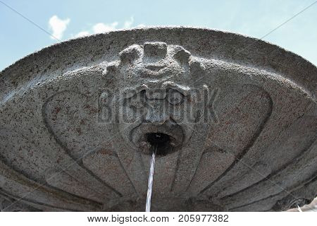 stone gothic mask fountain in Oropa Italy