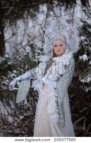 woman in a Snow Maiden costume in a winter forest