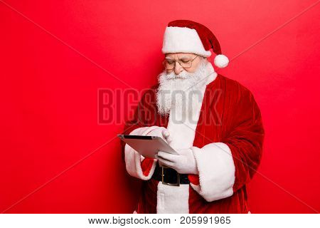 Concentrated Saint Nicholas Looks At Emails From Children About Gifts On Pda Digital Device Screen M