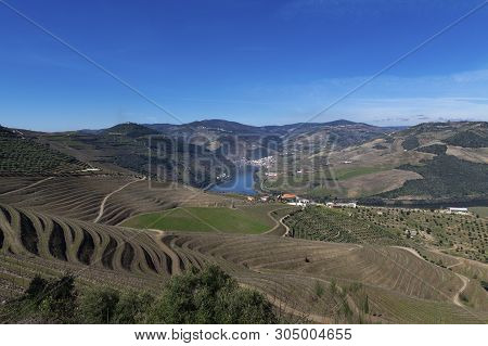 View Of Douro Valley With The Pinhao Village, Terraced Vineyards And The Douro River, In Portugal; C