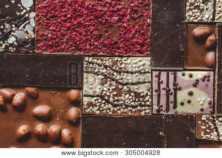 Background With Milk, Dark And White Chocolate Bar Pieces. Chocolate Pazl With Hazelnut, Peanut, Dri