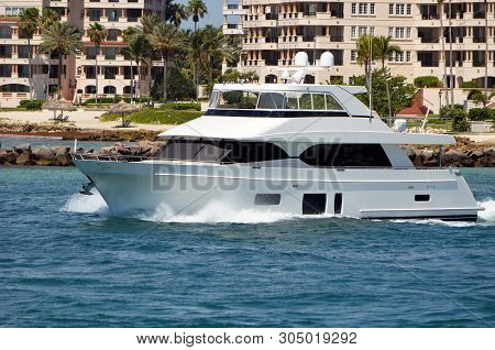 Luxury White Motor Yacht Cruising By Luxury Island Condominiums.