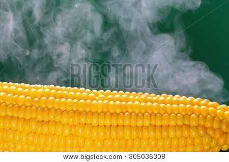 Boiled Corn With Steam On A Green Background.
