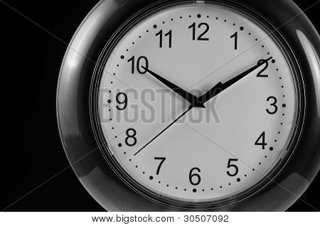 Monochrome Wanduhr auf schwarzem Hintergrund