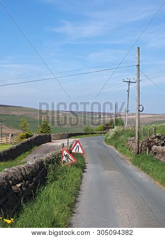 A Narrow Country Lane With Wooden Electricity Poles And Lines In A Sunlit Rural Landscape On The Old