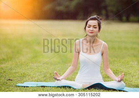 Woman Doing Yoga On The Park - Beautiful Lights.relax In Nature On The Park .