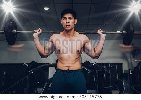 Muscular Man Working Out In Gym Doing Exercises With Barbell At Biceps, Strong Male.sian Handsome Mu