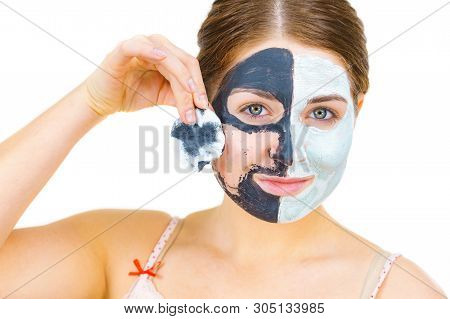 Woman With Clay Carbo Black Mask On One Half Face And White Mud On Second Half. Girl Removing Cosmet