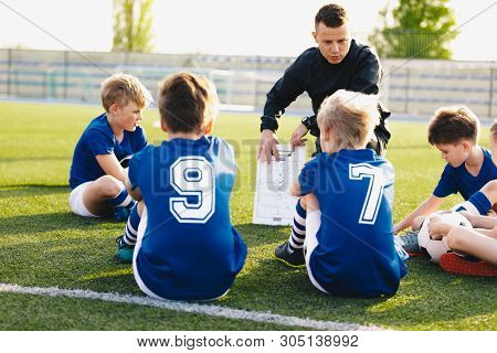 Football Coach Coaching Kids. Soccer Football Training Session For Young Boys. Young Coach Teaching 