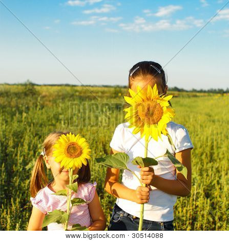 Due ragazze Cute Litle nascondendosi dietro girasoli