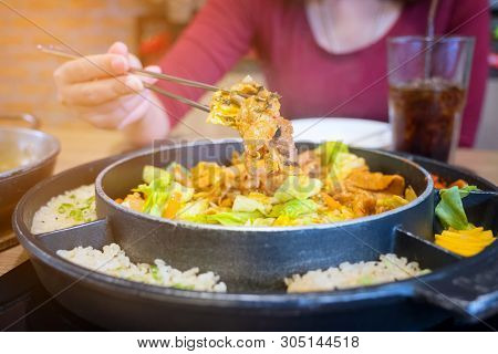 Dak Galbi Seafood On Hot Pan, Korean Food Spicy Stir-fried Chicken. Hand Use Chopsticks