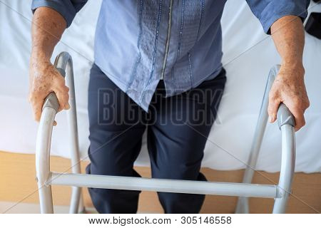 Close-up Of Female Patient Moving With Walker, Senior Woman Using A Walker In Hospital
