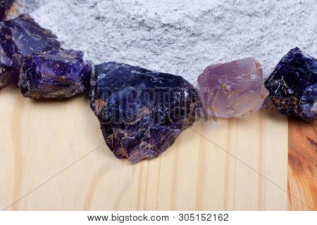 A Pile Of Fluorine Spar Surrounded By Fluorite Stones On Wood.