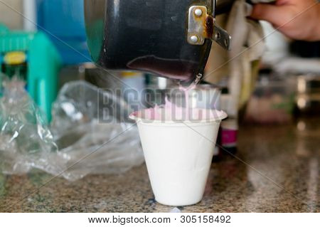 Molton Soap Base Being Poured From A Black Pan Into A Measuring Cup