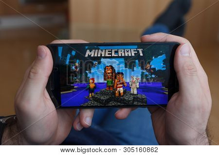 Los Angeles, California - June 3, 2019: Lying Man Holding A Smartphone And Playing Minecraft Game On