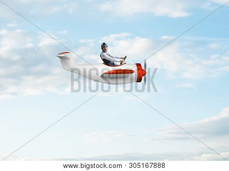 Happy Pilot Driving Small Propeller Plane On Background Of Blue Sky With Clouds. Traveling Around Th