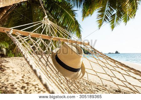 Close-up Of Sun Hat On Hammock Over The Sand At Beach