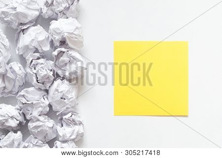 Brainstorming Concept. Flat Lay Of Crumpled Paper Ball Pile And Yellow Black Note On White Backgroun