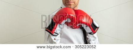 Wide View Image Of Businessman Wearing Red Boxing Gloves In A Defensive Position. Over Grey Backgrou