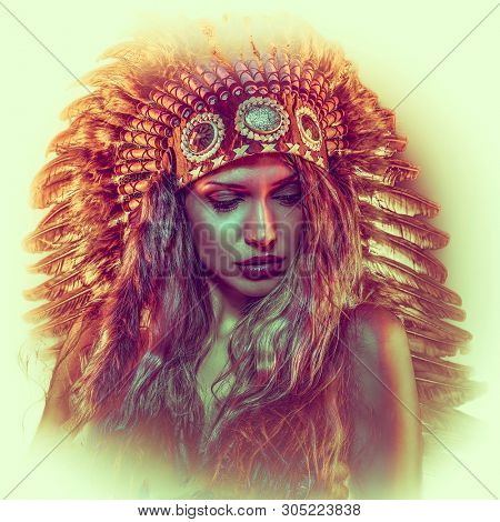 Colorful, beautiful girl with plume of american indian feathers
